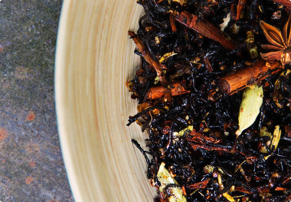 Préparation de sticky chai avec thé noir et épices entières dans un récipient